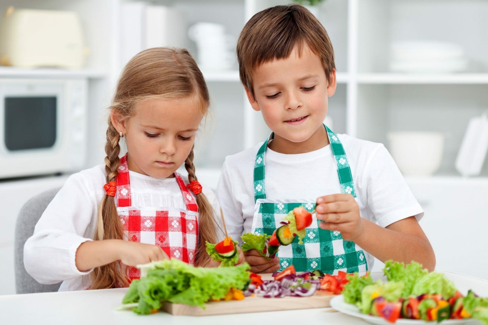 Two children are preparing vegetables in the Sugar Land kitchen.